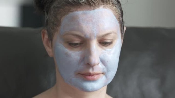 女人用面部保湿保湿化妆品面膜敷在脸上，在家做日常皮肤护理，女性脸部特写。