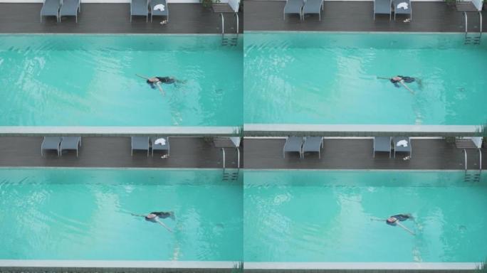 少女在游泳池游泳的鸟瞰图