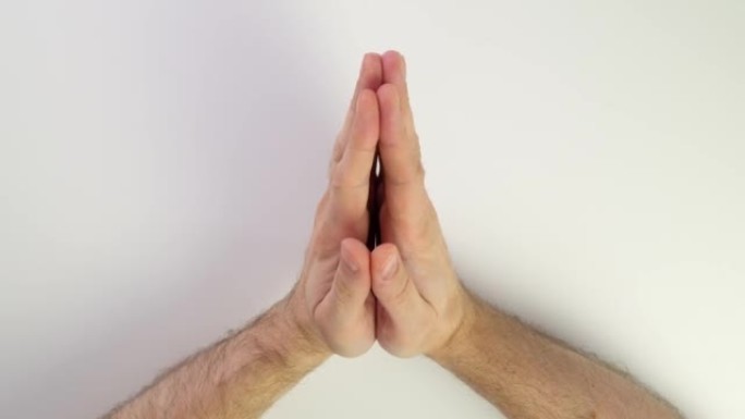 双手祈祷。白底白种人手的俯视图。手掌连接在一起。手指在右手和左手互相触摸，