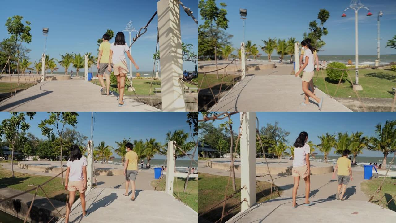 亚洲儿童在阳光明媚的日子里一起走向海滩，生活方式理念。