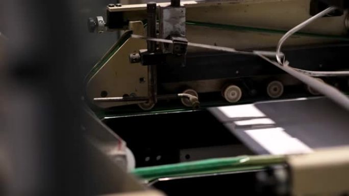 生产纸箱的工厂。自动折叠和胶合线。传送带上的纸板箱。折叠盒子特写。