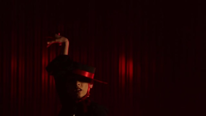 美丽的帽子穿着女孩跳拉丁舞。专业女舞者在红色背景上跳舞弗拉门戈舞，伦巴舞或萨尔萨舞，并带有线条。西班