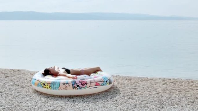 女人在亚得里亚海的海滩上晒日光浴。