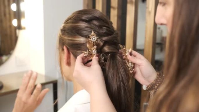 理发师在给客户做婚礼发型时，给她贴上时尚的发饰。