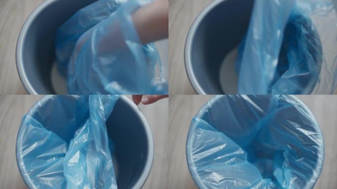 女性双手将塑料袋放在室内的垃圾箱中。无法辨认的整洁的高加索年轻女子打扫房子准备食物的容器。特写。
