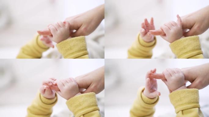 亚洲婴儿握着妈妈的手指