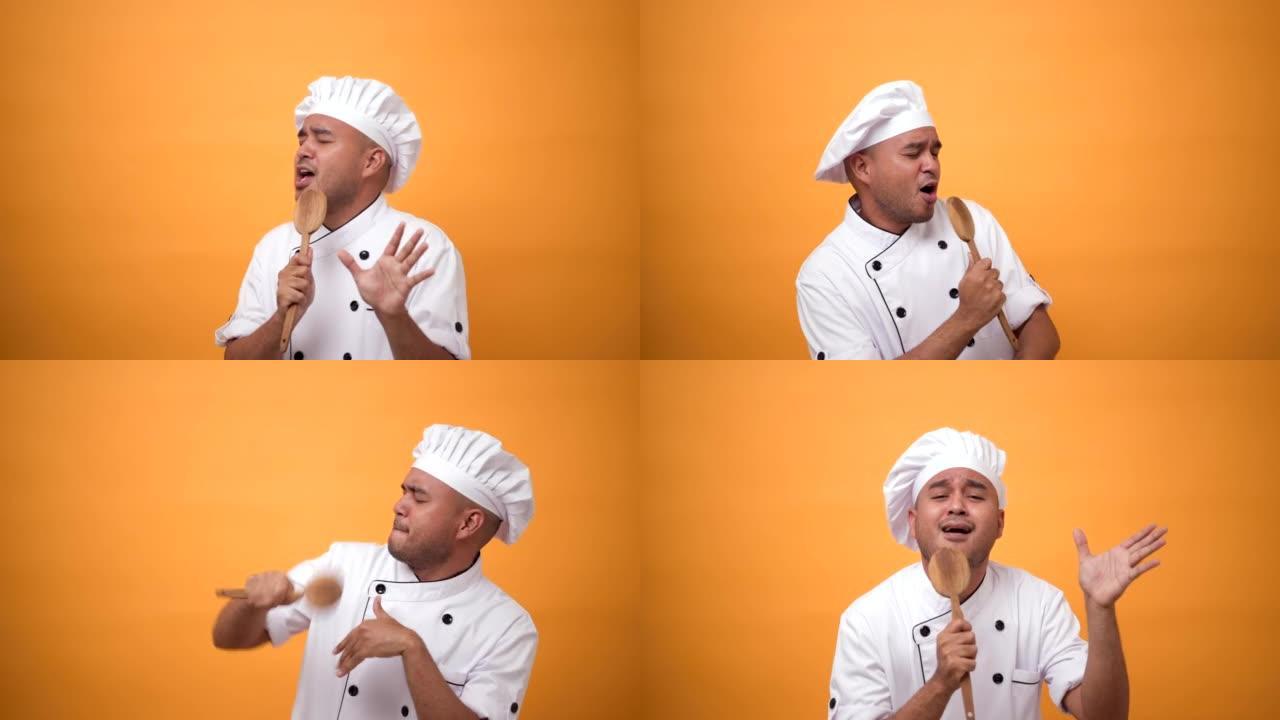 肖像快乐有趣的男人厨师拿着厨房用具跳舞和唱歌的音乐孤立在黄色背景上。
