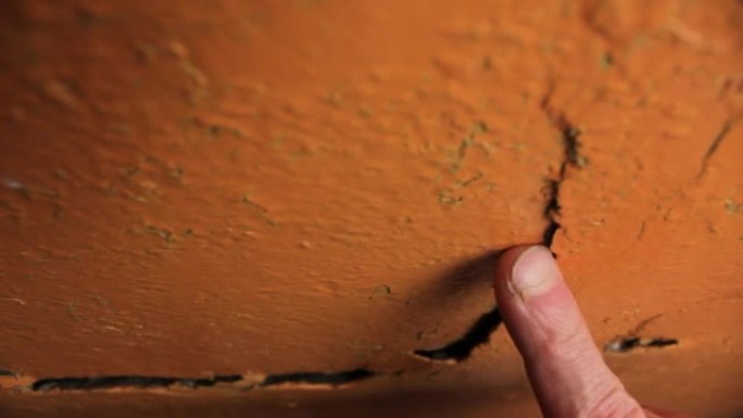 墙上的裂缝特写。开裂的墙泥和油漆。