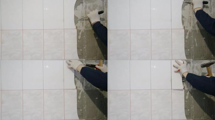 工人从厨房的墙壁上拆除了旧瓷砖。在公寓里修理，复制文本空间。工业
