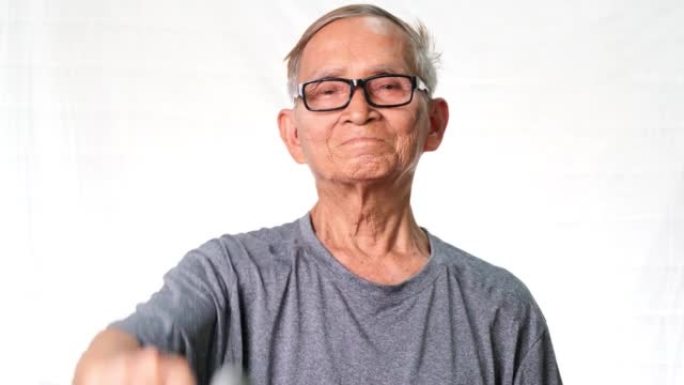 亚洲老人举起哑铃，露出手臂肌肉。健康的生活方式