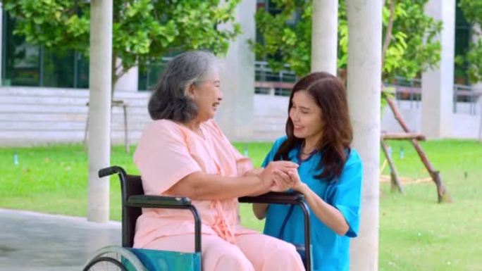 亚洲细心的照顾者或护士在轮椅上照顾病人。从照顾者，储蓄和高级健康保险，一个幸福的家庭，照顾幸福的退休