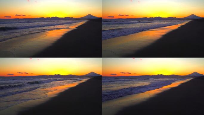 富士山和日落时的沙滩。逃离海浪的小鸟