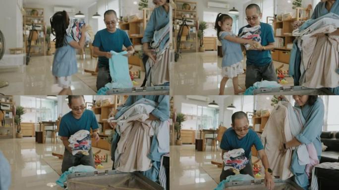打包家庭旅行，小女孩想通过帮助父母折叠衣服来享受父母的乐趣。