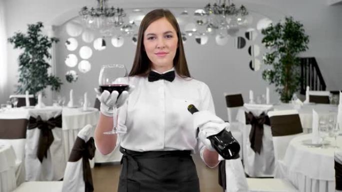戴着白手套的女服务员拿着一杯和一瓶红酒
