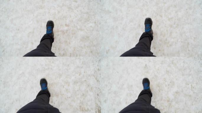 冬天，一个穿着黑色靴子的男人的腿在雪地里行走。视点视频。