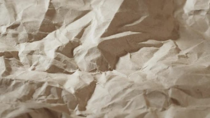 皱巴巴的工艺纸特写。回收棕色床单纹理，旧米色表面背景