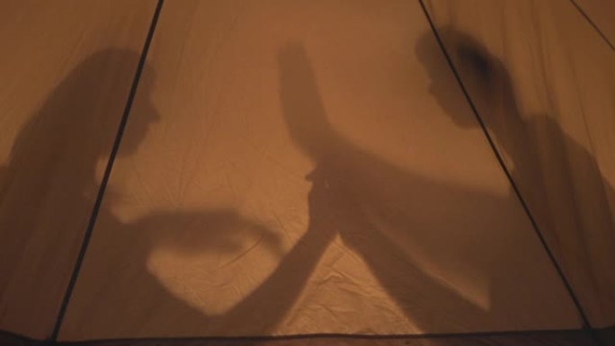 快乐的亚洲夫妇帐篷里的影子正在度假。