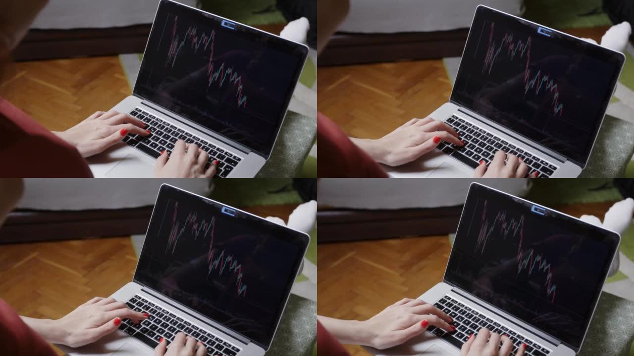 年轻女子在笔记本电脑上跟踪股市图表的实时供稿