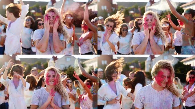 可爱的女人在脸颊上溅起彩色粉末，微笑着，在慢动作的洒红节上玩得很开心。人们庆祝印度教节日和冠状病毒大