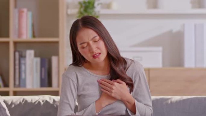 一名亚洲妇女有心脏病发作的症状，这是使人死亡或紊乱的主要结果。有许多症状，如胸痛，胸部压力和背部不适