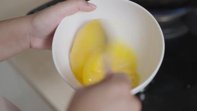 用叉子准备和混合鸡蛋煮炒鸡蛋