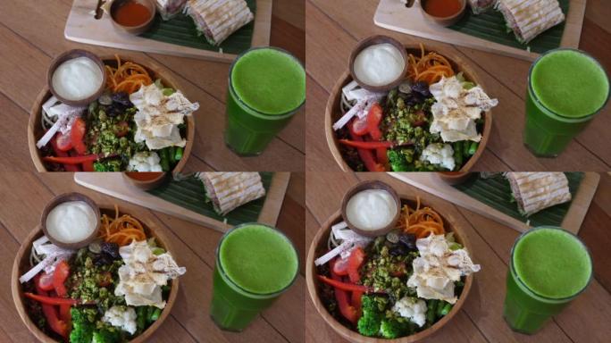 餐桌上营养蔬菜午餐的俯视图，素食碗，美味的沙拉三明治卷和新鲜的绿色冰沙。健康的营养可以延长您的寿命并