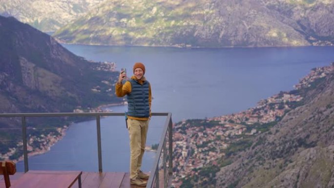 一个男人在秋天在黑山旅行。他从山上的角度看博卡·科托尔斯卡湾