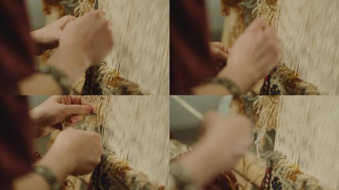 4k一个女人编织传统的亚洲地毯。手工地毯刺绣。女性的手使用多色线创建图案。特写视图。织机。针线活。地