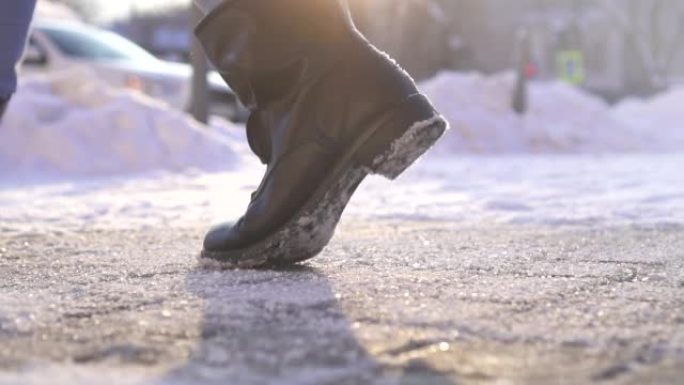 脚行人在冬天行走在冰上撒上防滑试剂特写，慢摩