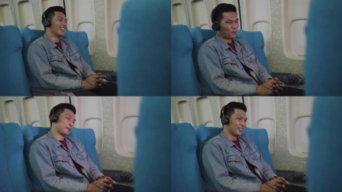 亚洲旅客旅客在飞机上看电影或在飞行中戴着耳机听音乐