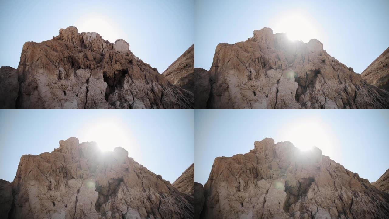 岩石的特写视图。阳光在湛蓝的天空中。死海附近沙漠中的山岩