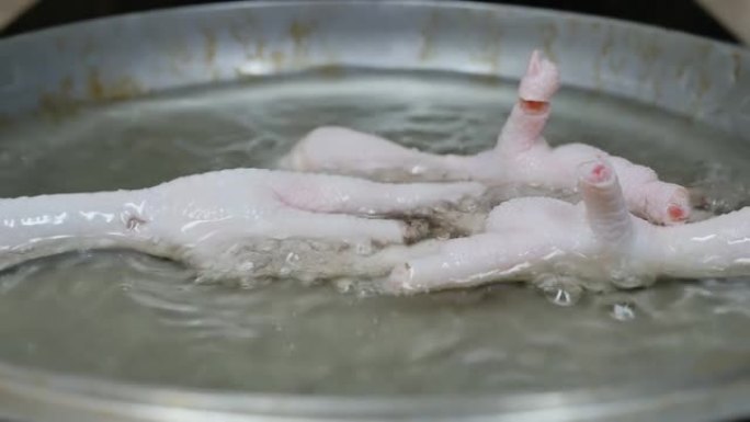 厨师把鸡爪放进锅里的热脂肪里。韩国食品
