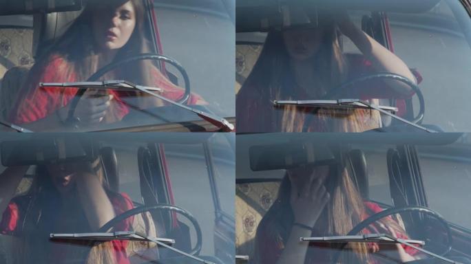 汽车方向盘后面的人的行为变体。一名年轻女子坐在一辆旧车的方向盘后面，立即看着后视镜，