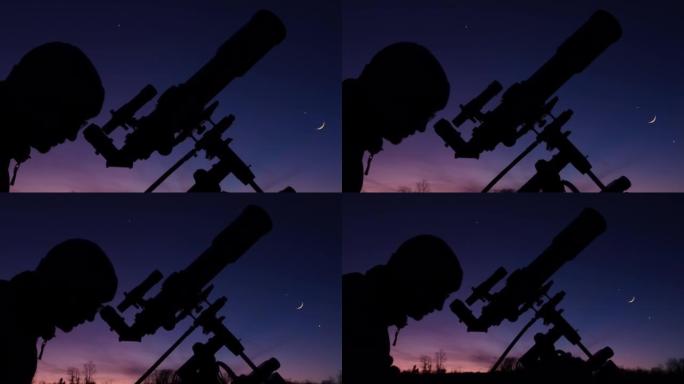夜空下男人、望远镜和乡村的轮廓。