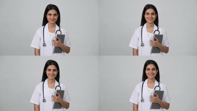 年轻的印度医生穿着白色制服和听诊器，手持ipod平板电脑。