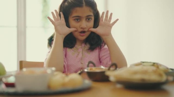 一个印度女孩在家享受晚餐。