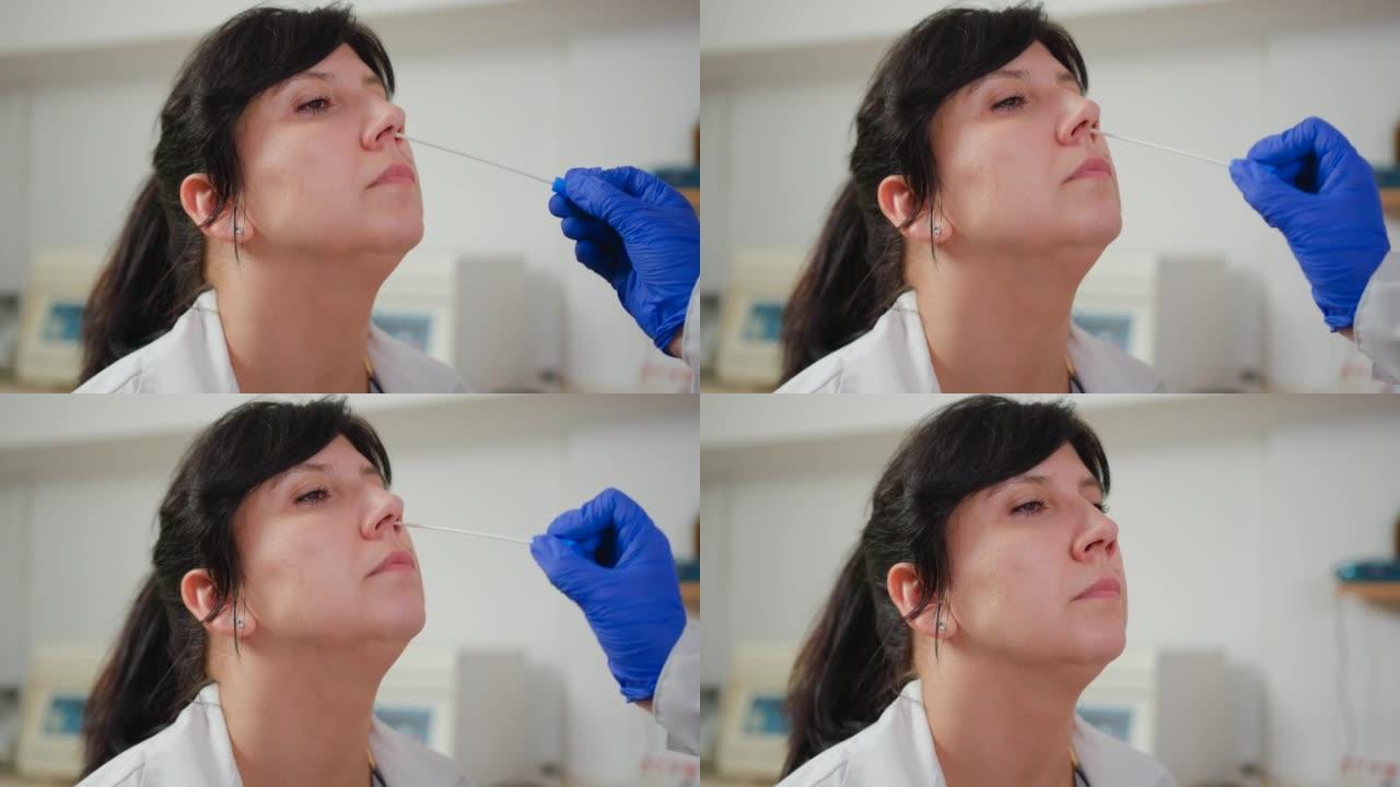 护士从一名女性患者身上采集鼻拭子样本。新型冠状病毒肺炎