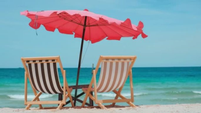 彩色沙滩椅在棕色的沙滩和蓝色的水，小浪移动和多云的天空在泰国南部
