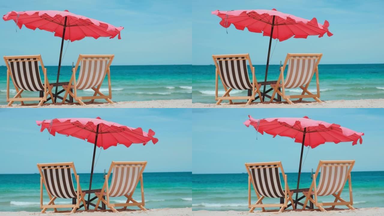 彩色沙滩椅在棕色的沙滩和蓝色的水，小浪移动和多云的天空在泰国南部