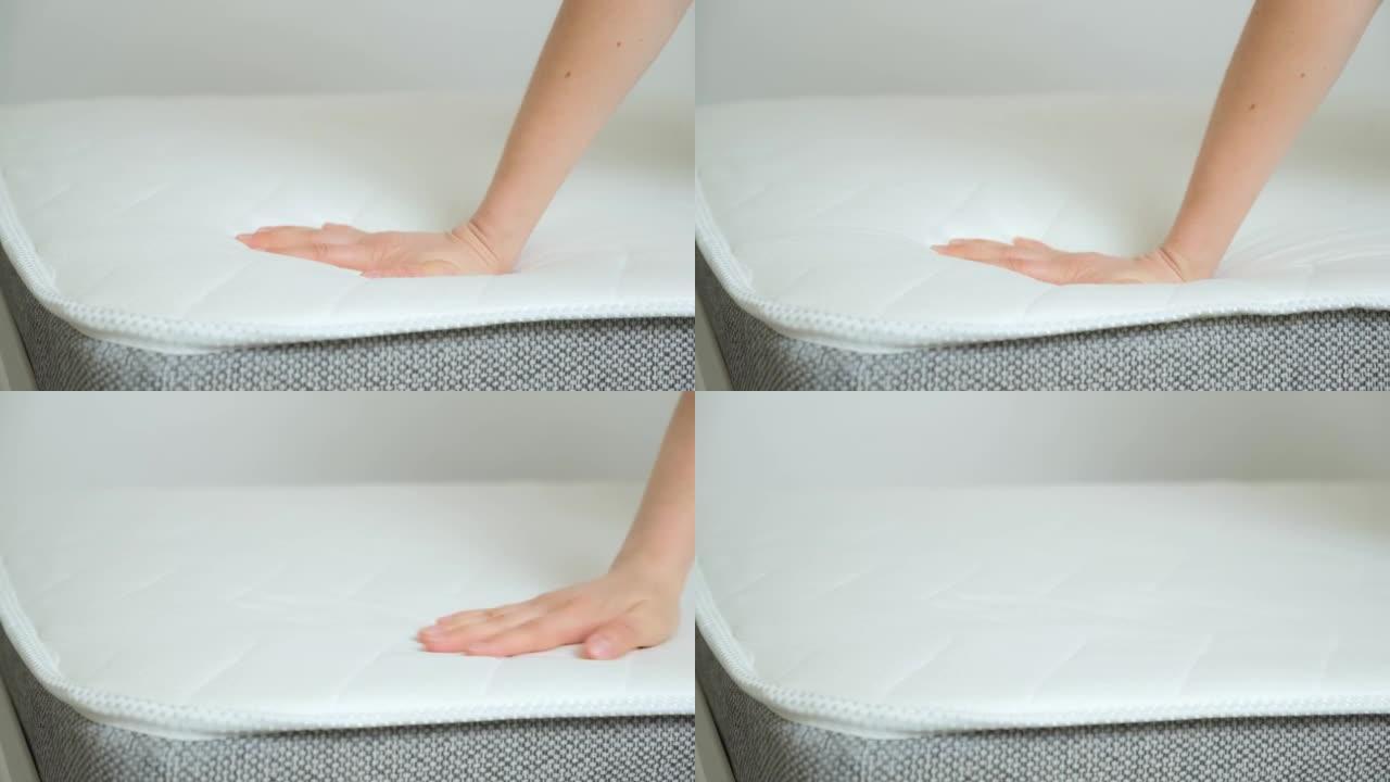 一名妇女将手按在矫形床垫特写上。