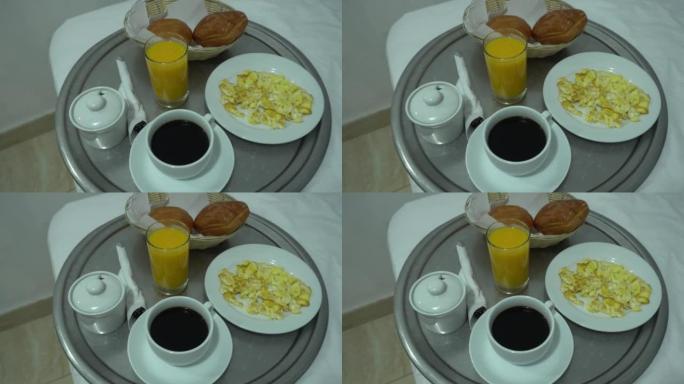 酒店早餐的特写镜头，包括炒鸡蛋，咖啡，苏打水和面包