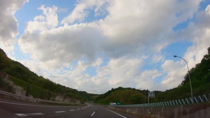 在高速公路上行驶的汽车的景色，美丽的蓝天和云