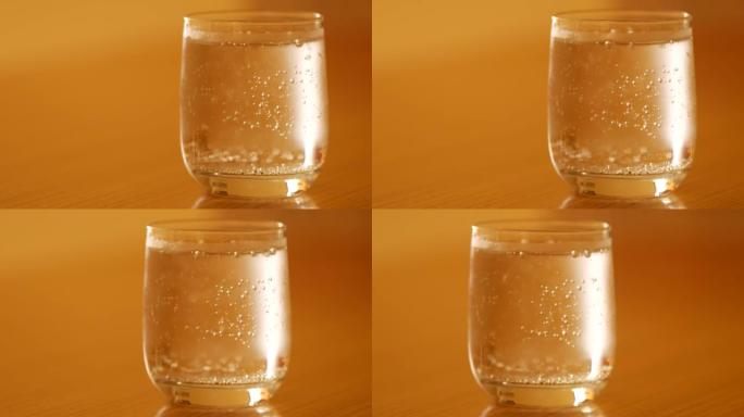 一杯冷苏打水。气泡上升到表面并破裂。在高温中喝酒解渴。玻璃中的碳酸矿泉水