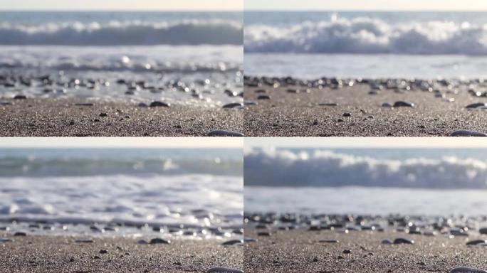 精细的黑色，白色和米色颜色的海石卵石的特写纹理。岩石海滩上海浪的泡沫。石头背景的平滑运动。