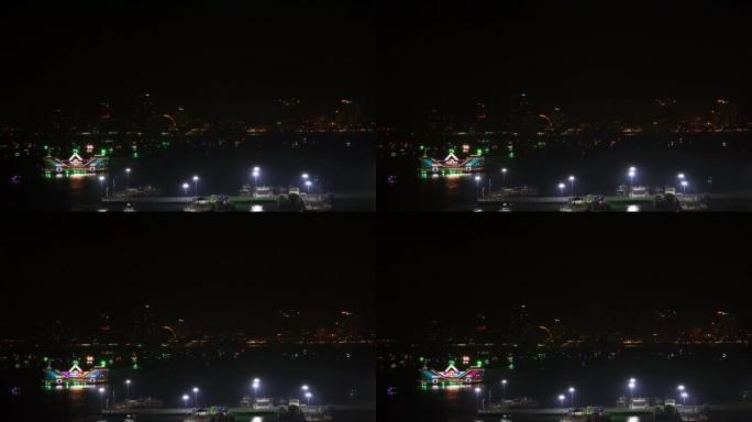 芭堤雅湾的浮动餐厅和渔船在芭堤雅市的夜灯下等待游客