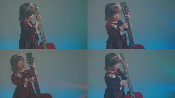 穿着复古连衣裙的小女孩像低音提琴一样弹着原声吉他