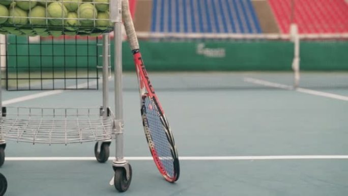 空网球场，配有网球车和球拍。