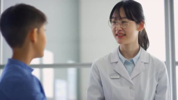 亚洲女医生和男孩在诊所里击掌