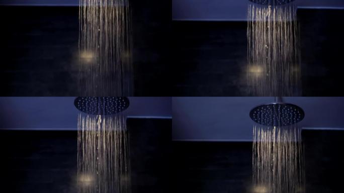 雨水淋浴水在带灯的黑暗室内浴室中向下流动