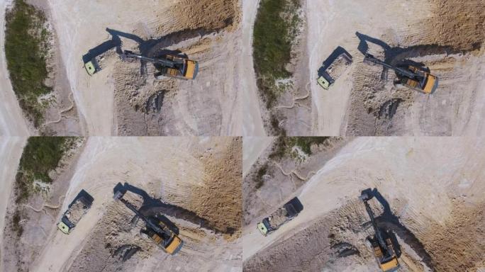 现代挖掘机在采石场上铲高岭土。装载卡车离开工厂。
